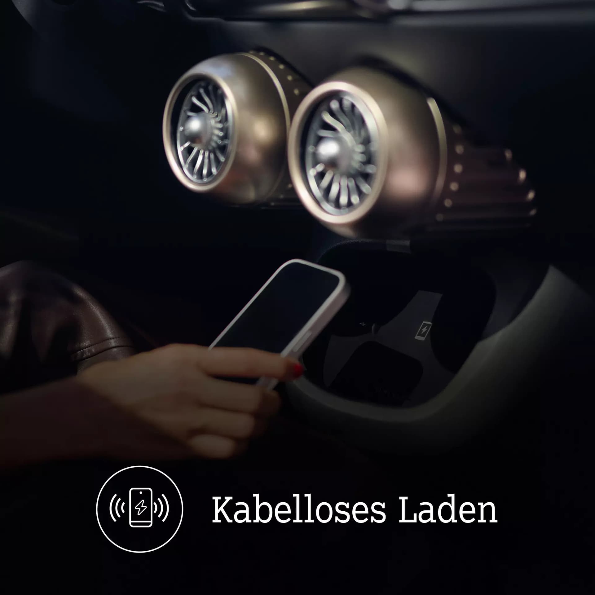 Detailaufnahme der kabellosen Smartphone-Ladefläche im smart #2 mit zwei runden Lüftungsdüsen und dem Schriftzug „Kabelloses Laden“.